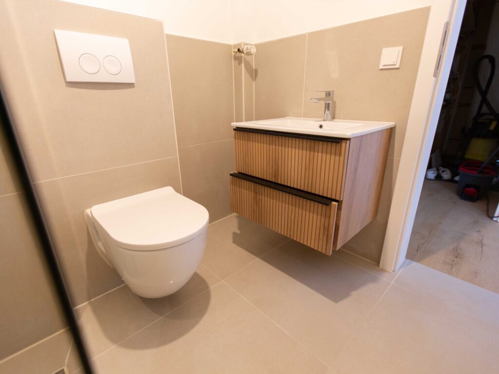 Sanitärinstallation in Köln mit modernem Waschtisch, wandhängendem WC und hochwertiger Badausstattung nach Badsanierung